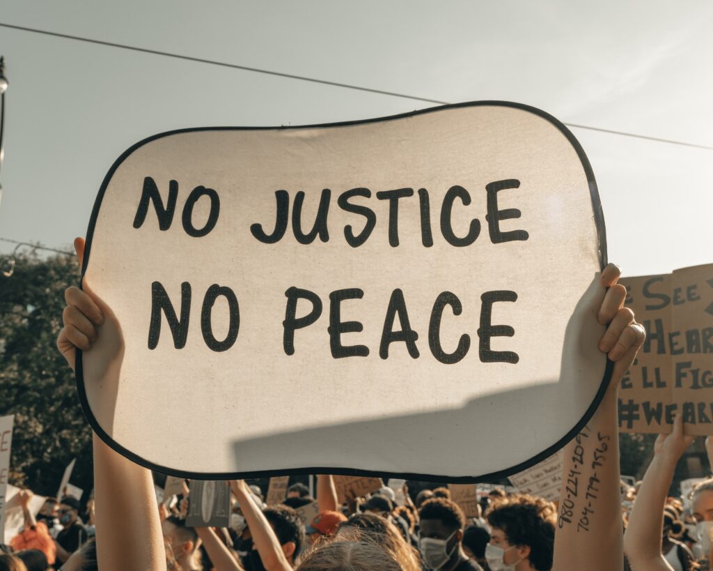 Person holding up sign - No Justice No Peace