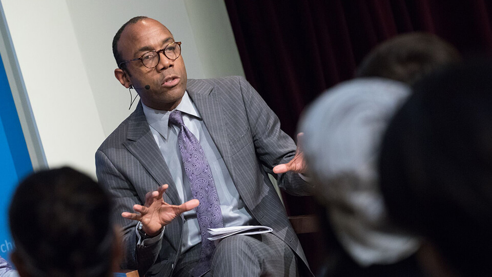 Cornell William Brooks facing an audience, talking to them, and expressing himself with a hand gesture.