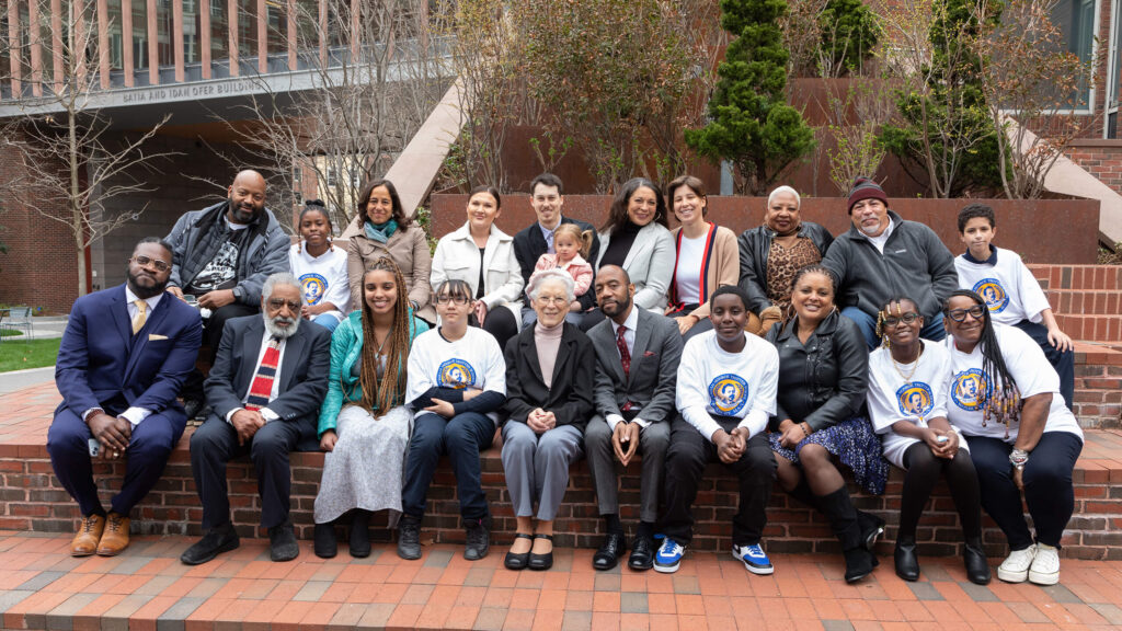 A group of participants at the Trotter 150 anniversary celebration. They are sitting on a brick wall outdoors in Harvard Square. .