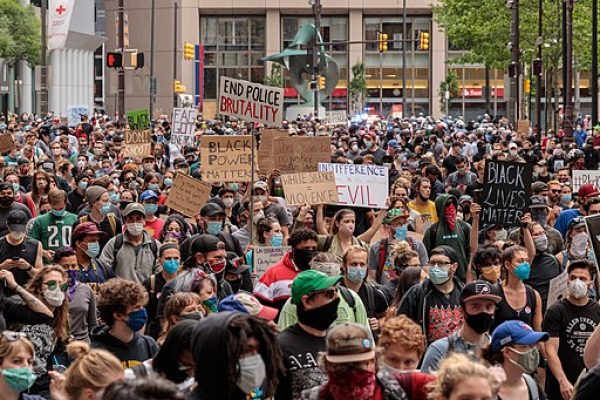 Thousands protest against police brutality. People holding signs.