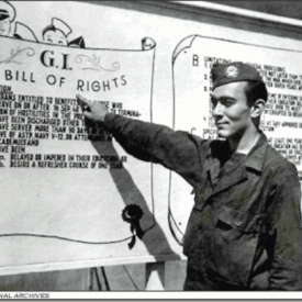Solider pointing to a sign explaining the GI Bill of Rights